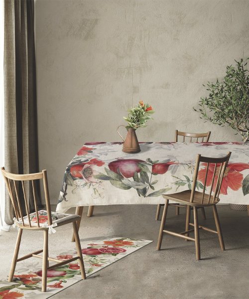 Tovaglia antimacchia modello Melograna stesa su un tavolo da pranzo in legno, all'interno di una sala moderna con sedie coordinate e runner abbinato a terra.