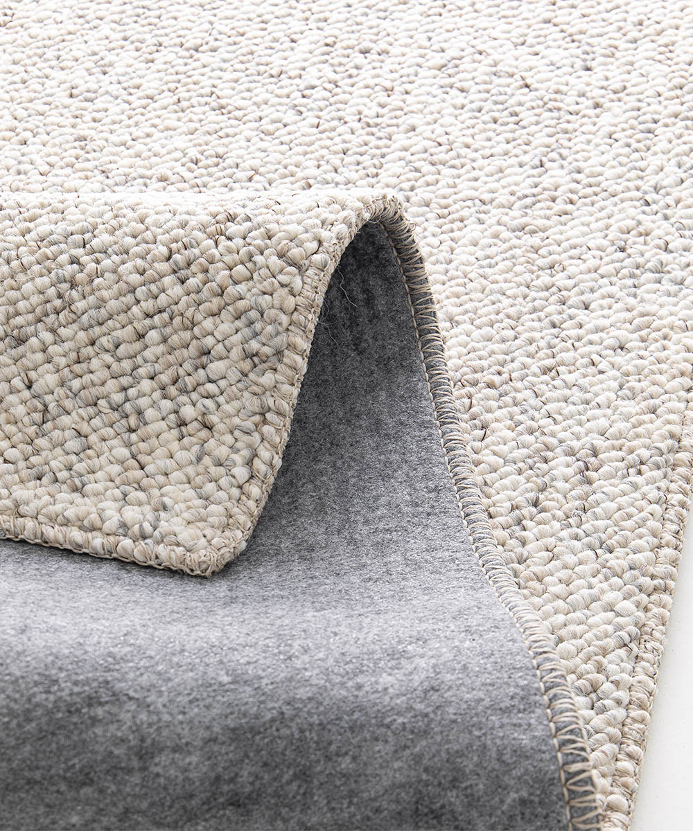 Angolo con retro del Tappeto bouclé PABLO GREIGE tessitura effetto riccio, colori naturali e design minimal in stile scandinavo. Morbidi, resistenti ma anche pratici e facili da lavare: lavatrice e asciugatrice.